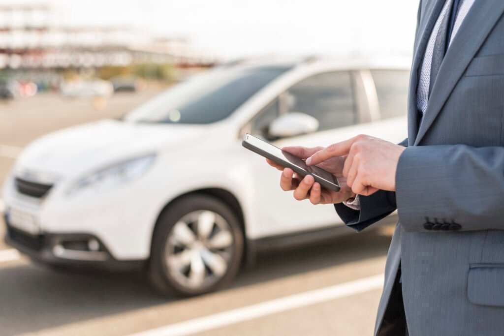 businessman-with-smartphone-front-car